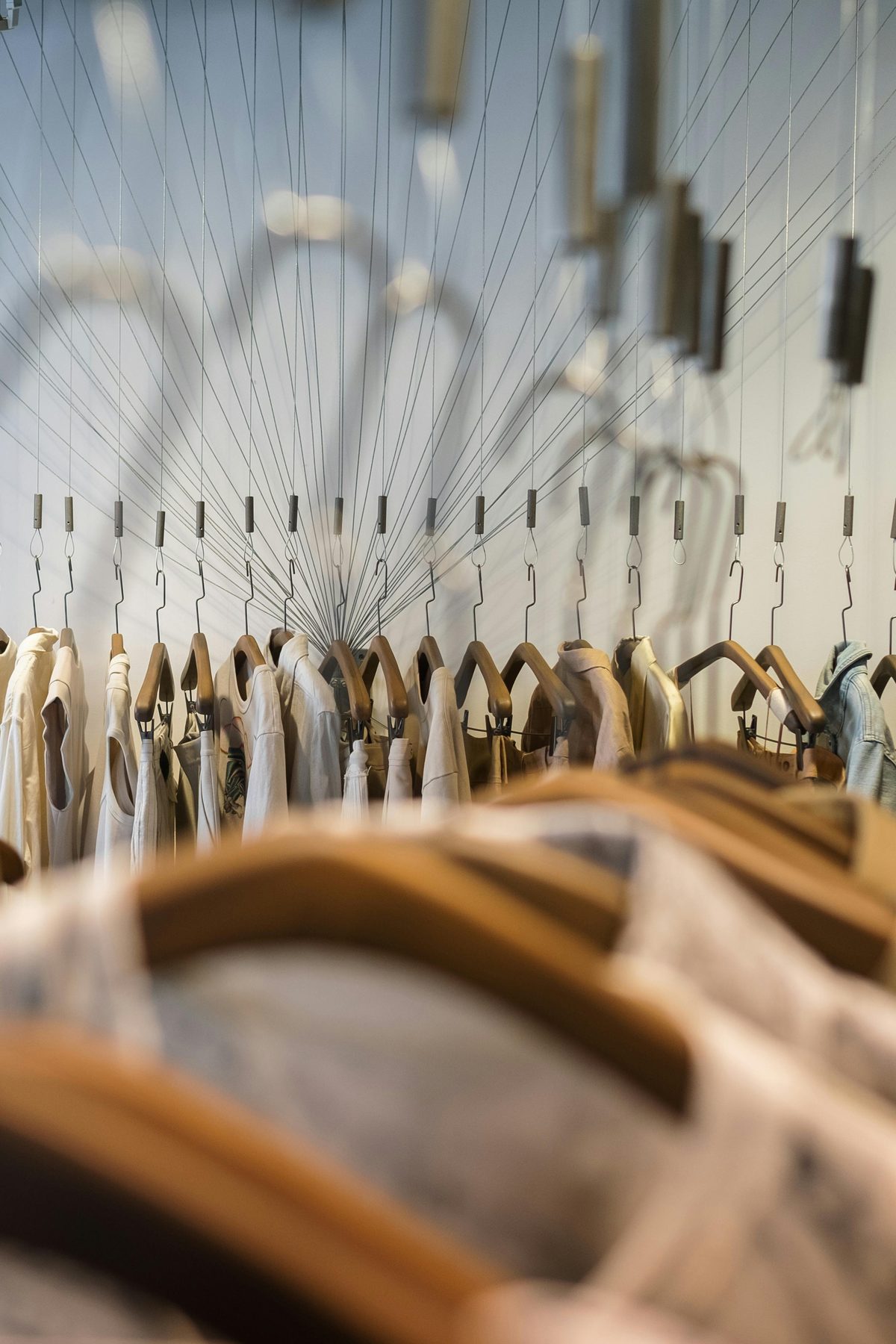 Rail of garments on wooden hangers
